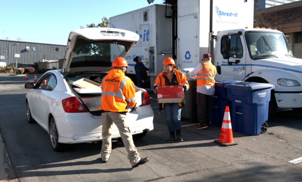 Shred It truck with EDCO employees carrying boxes