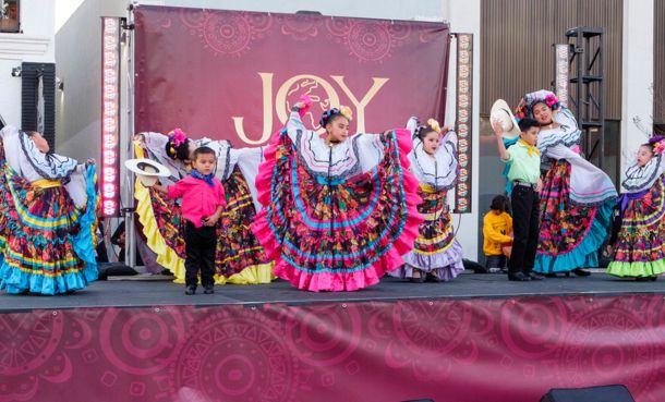 Children performing on stage in colorful costumes