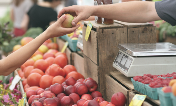 Street vendor giving another person an apple