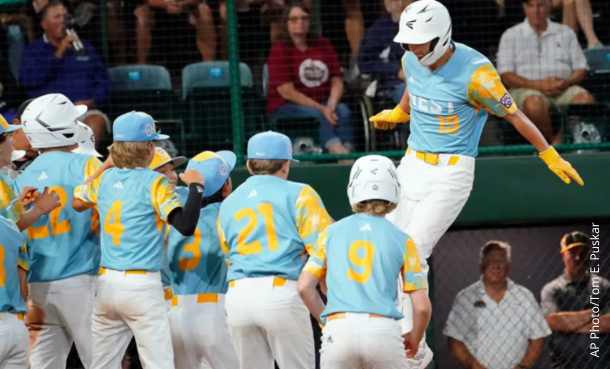 El Segundo Little League player Louis Lappe crossing home plate with team members cheering him on