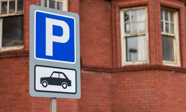 Parking sign in front of brick building