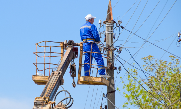 Power lines with an electrician in a cherry picker