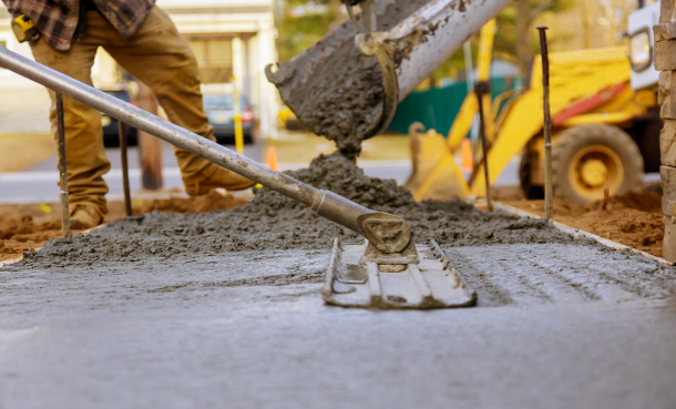 Construction worker smoothing freshly poured concrete