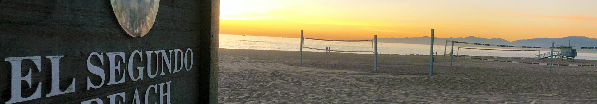 El Segundo Beach sign at sunset with volleyball nets